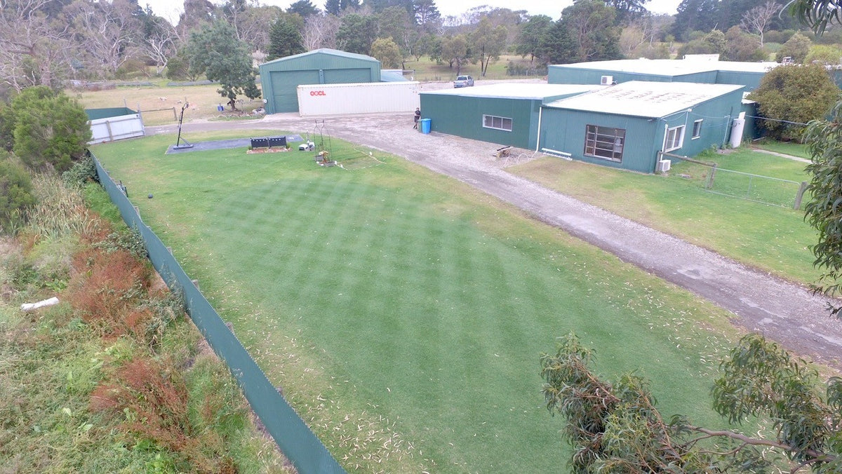 An aerial view of the striped turf and buildings at Turfmate.