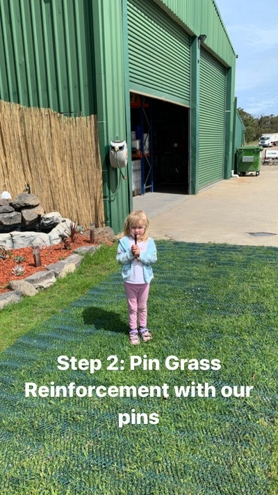 A girl standing on green grass reinforcement mesh beside the Turfmate shed.