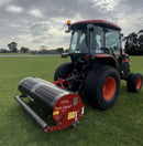 Orange tractor with a 'Verti-Drain' attachment on a grassy field